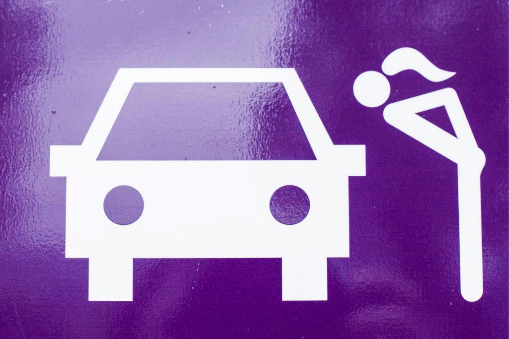 Sign depicting sex worker and a car