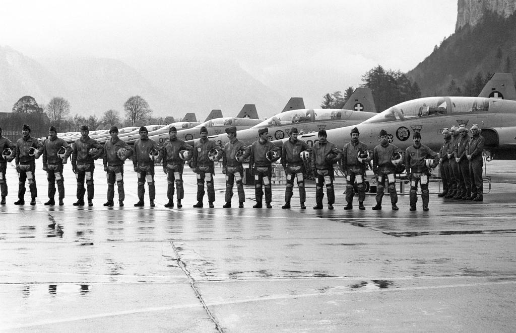 aeroplanes and soldiers stand on parade at an airfield