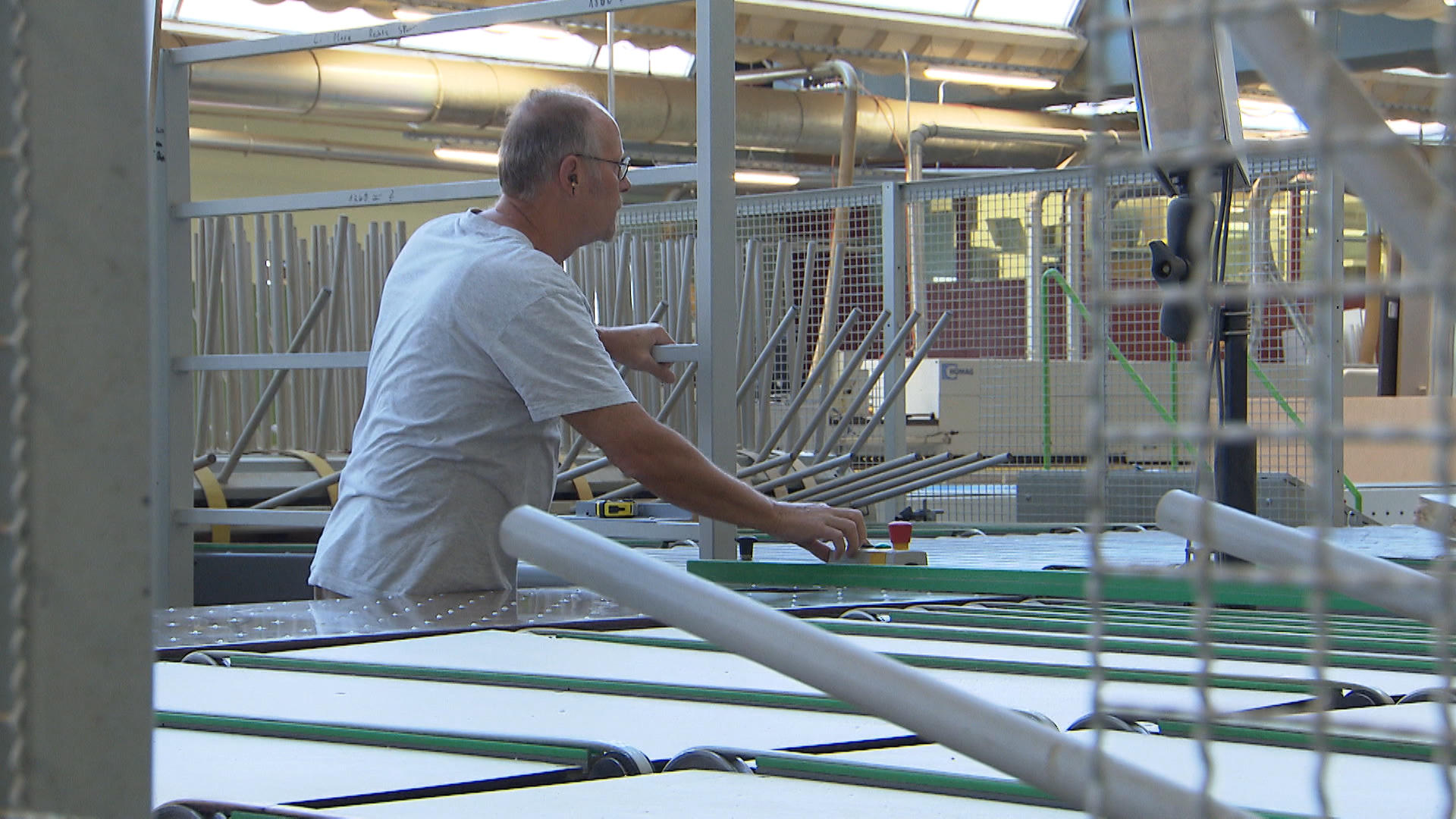 Man pressing machine button in factory hall