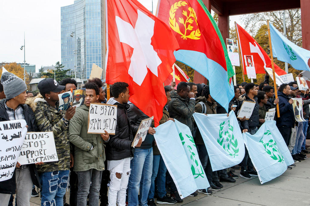 gruppo di eritrei manifesta con bandiere svizzere ed eritree a Ginevra