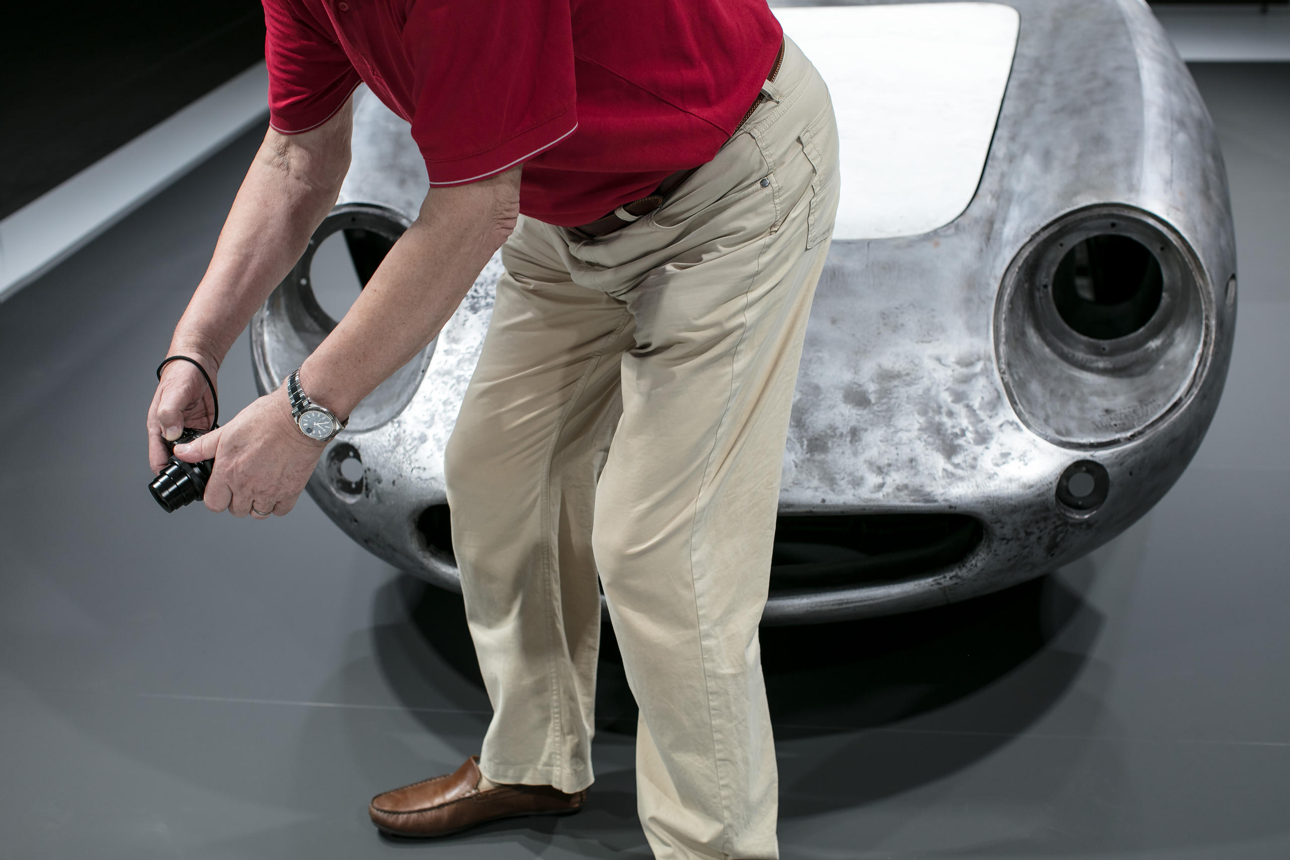 un uomo sta fotografando davanti a una carrozzeria grezza