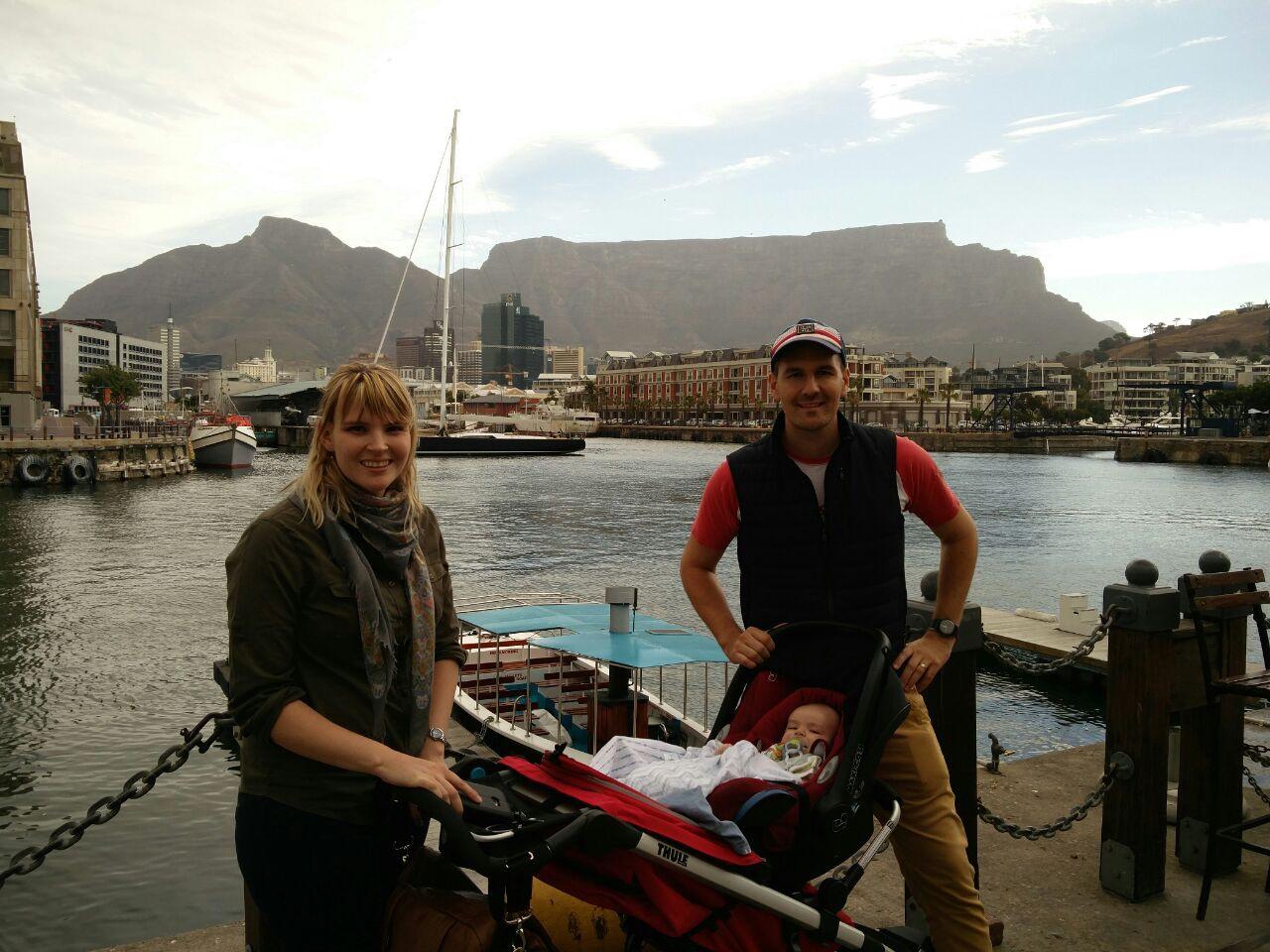 Frau, Mann und Baby im Kinderwagen vor dem Tafelberg in Kapstadt, Südafrika