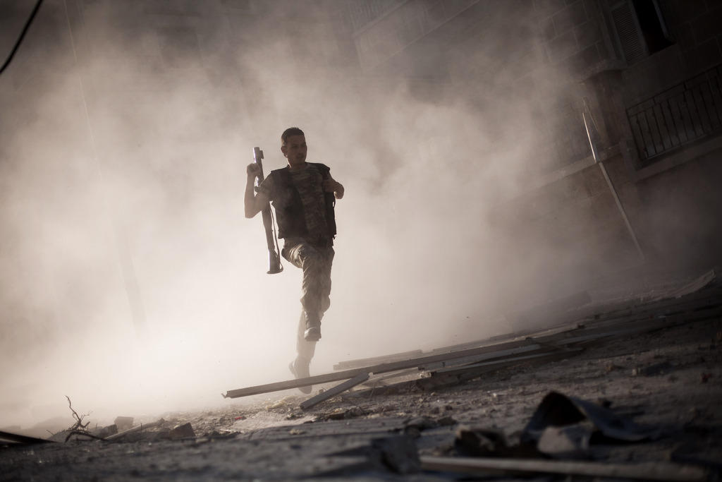 Syrian rebel standing in debris holding an RPG