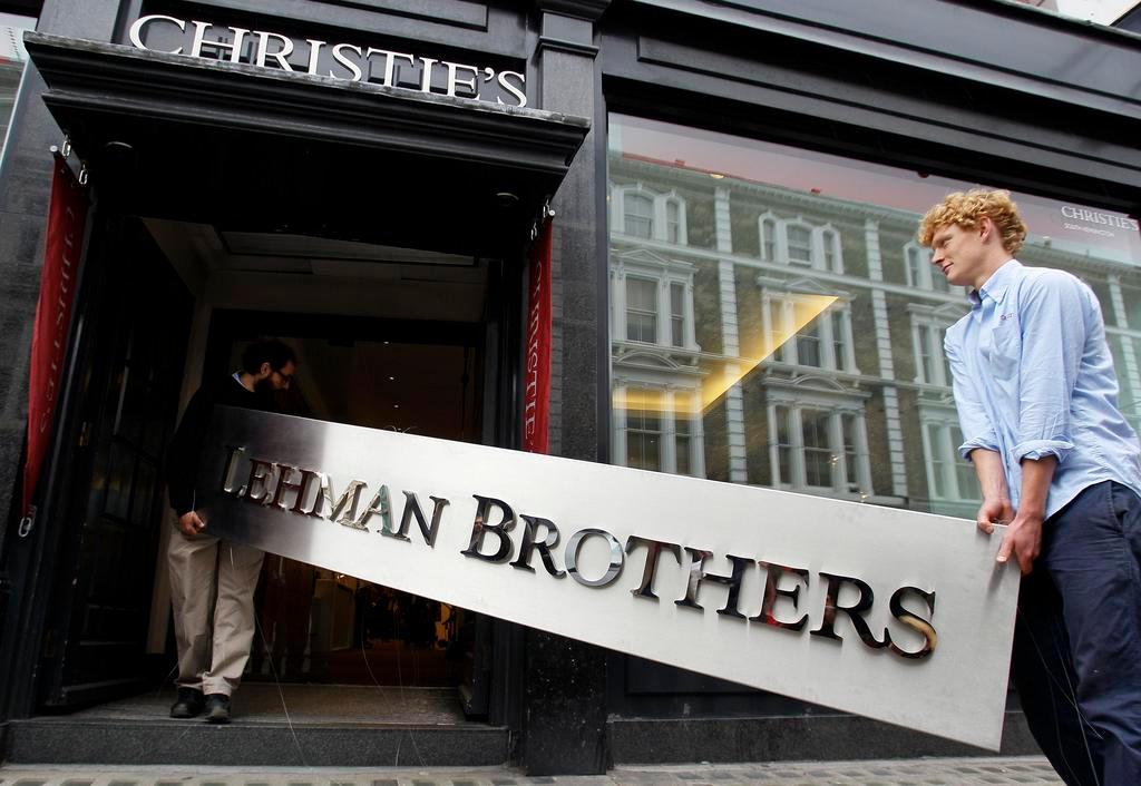 Two men carry a Lehman Brothers sign into a Christie s auction house