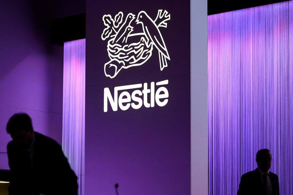 Two people in shadow with large Nestlé logo in the middle