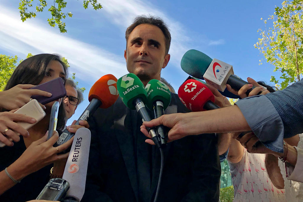 man surrounded by reporters