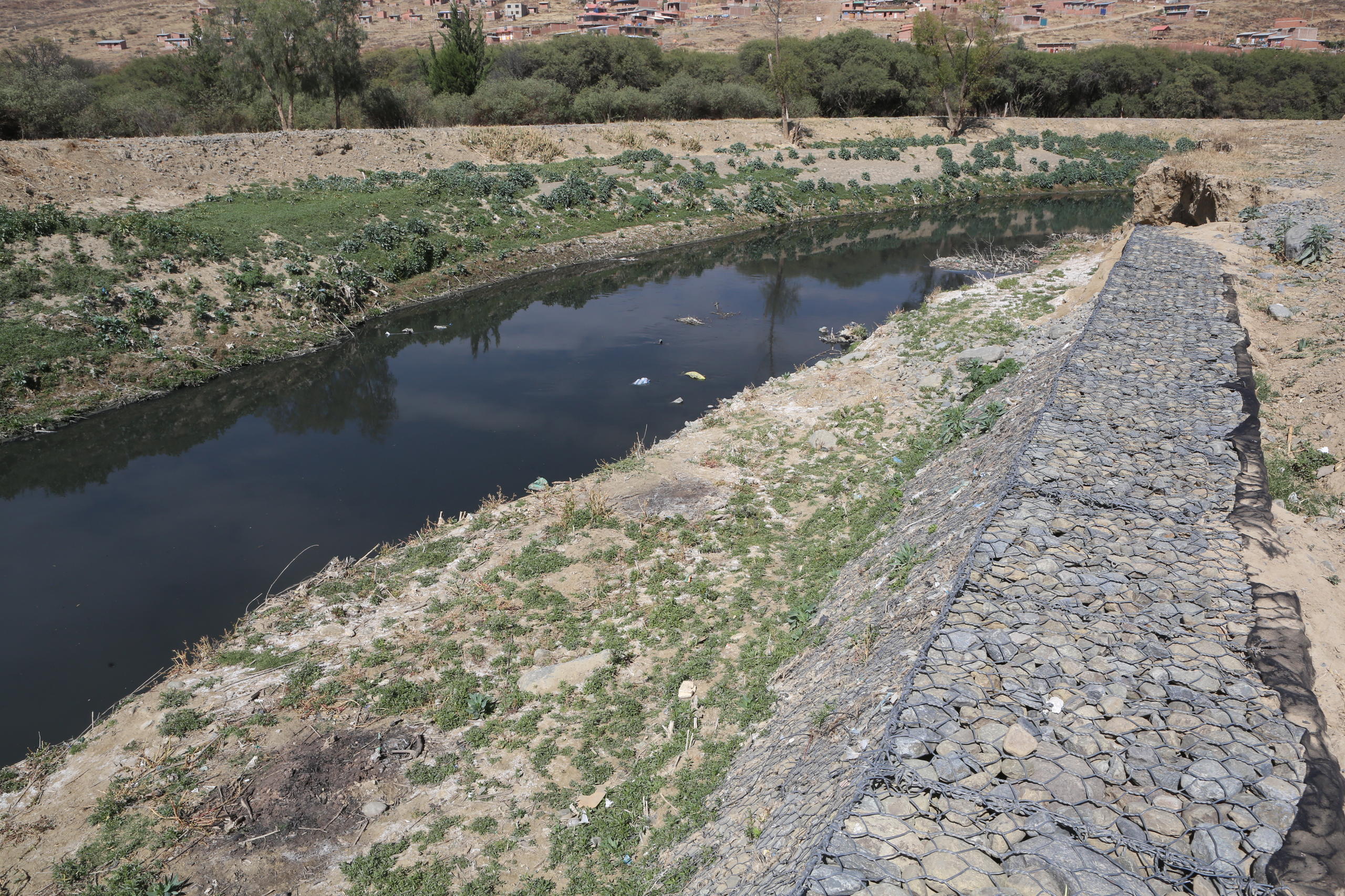 Malla metálica de protección en la ribera del río Rocha.