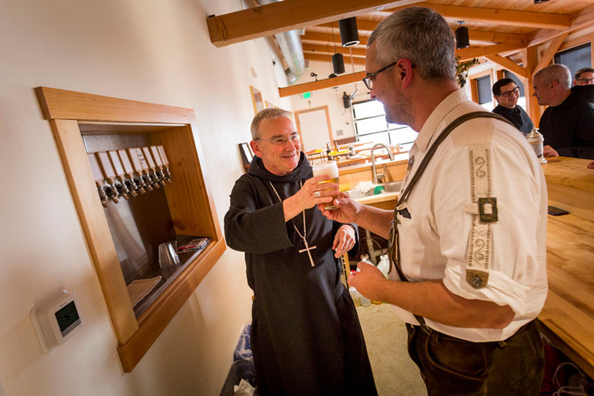 An abbot holds a pint of beer