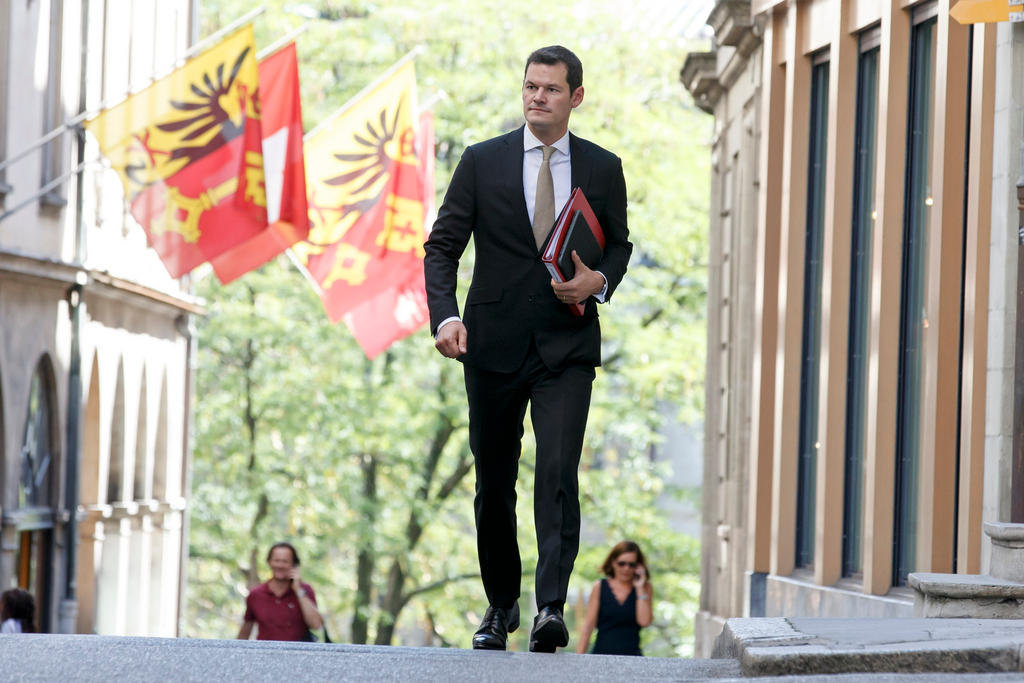 Pierre Maudet in una foto f archivio mentre cammina con dossier in mano nella città vecchia di Ginevra