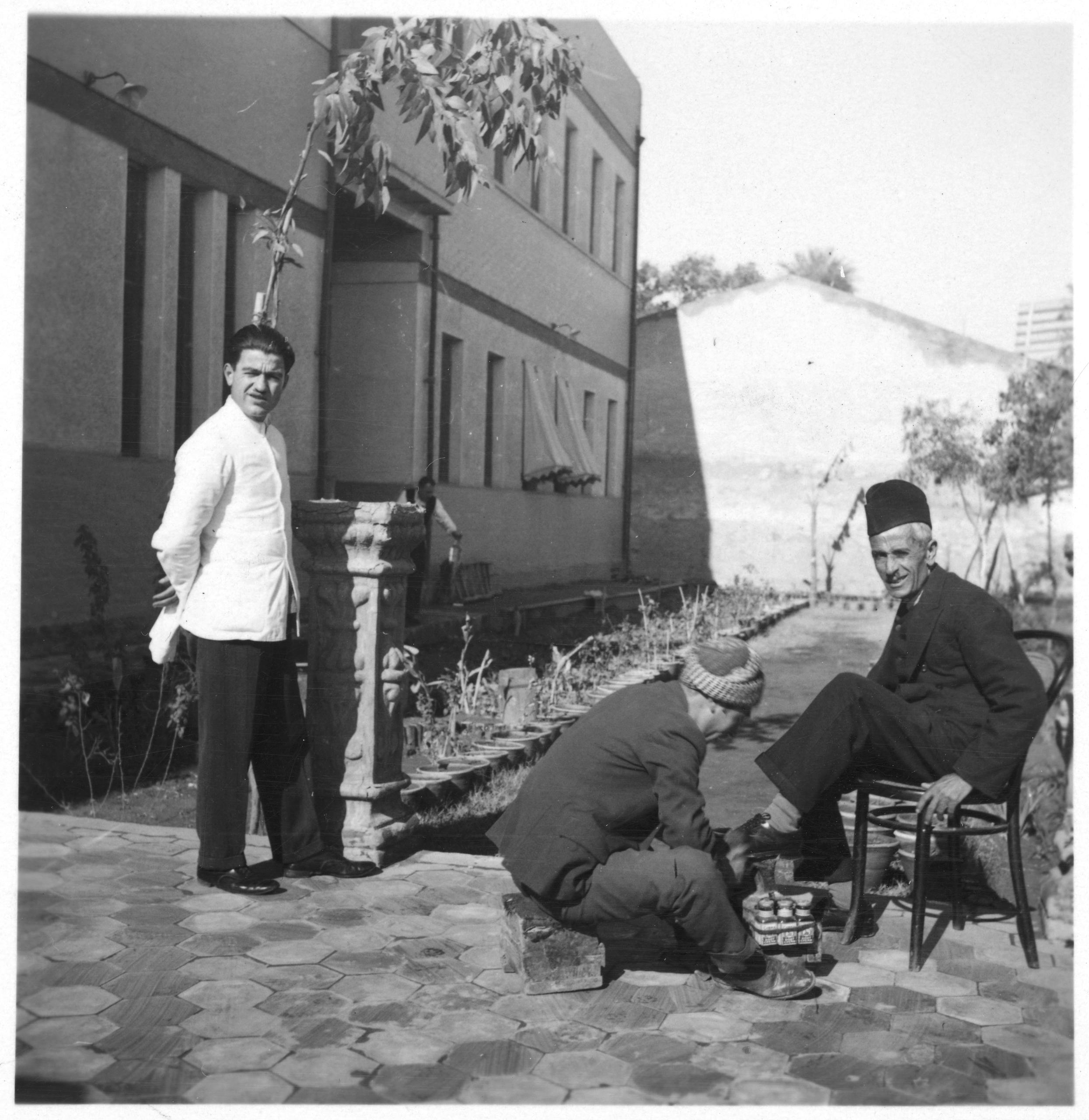 Um servente, um engraxate e seu cliente em Bagdá
