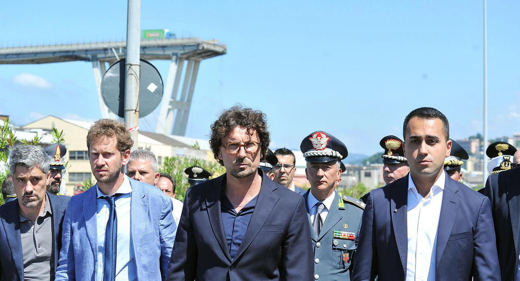 Il ministro Toninelli con sullo sfondo il ponte Morandi distrutto