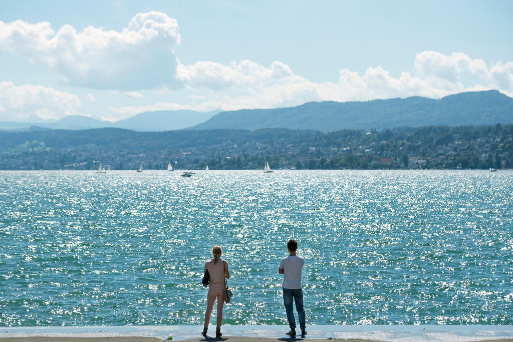Dos personas a orillas de un lago