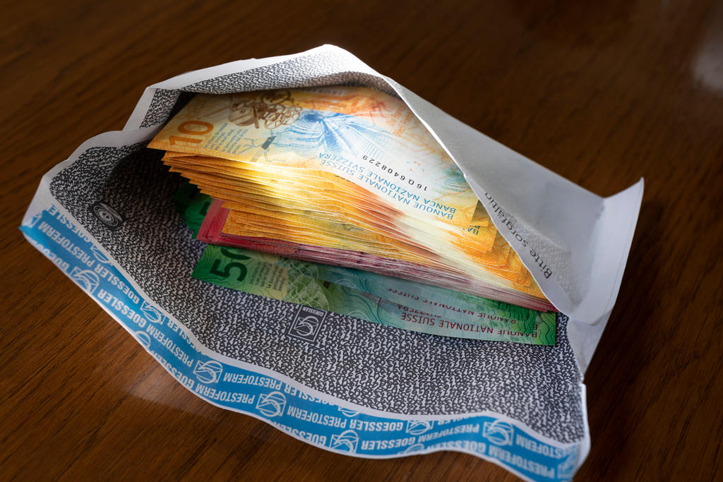 An open envelope reveals a stack of Swiss banknotes