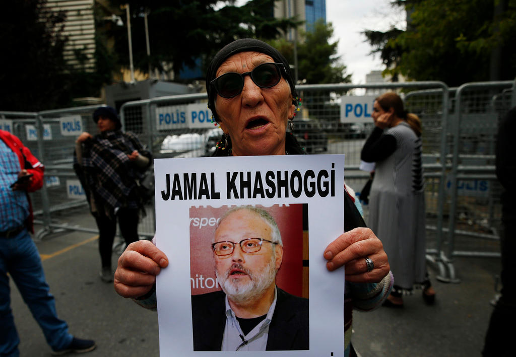 Eine ältere Person mit Sonnebrille hält ein Plakat mit einer Aufnahem von Jamal Khashoggi in den Händen.
