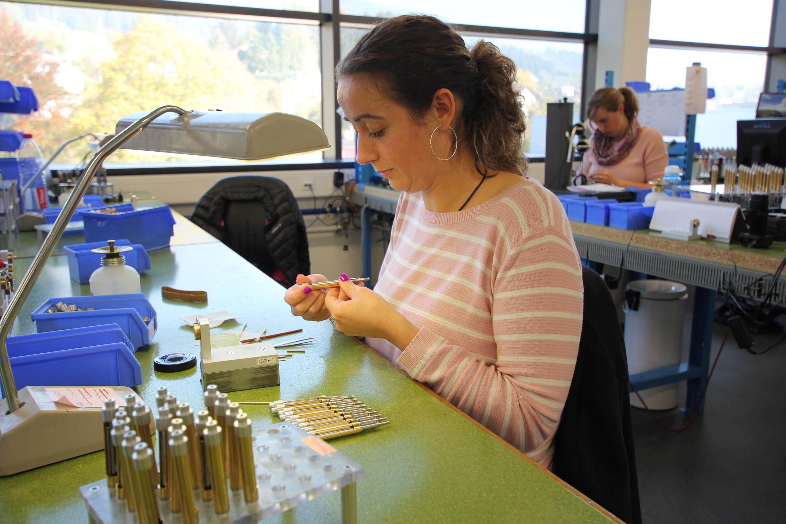 Una mujer trabajando en un taller de montaje de instrumentos de medición