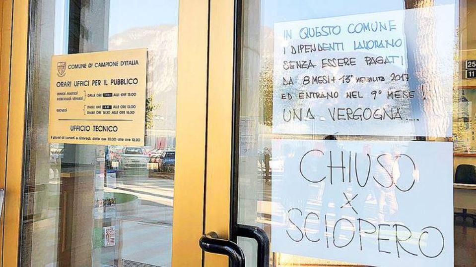 Sulla porta d entrata del comune un cartello con scritto Chiuso per sciopero