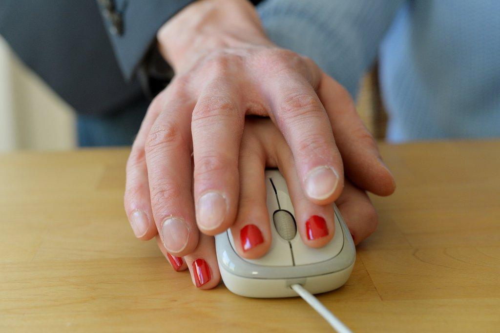 Deux mains l une sur l autre sur une souris d ordinateur