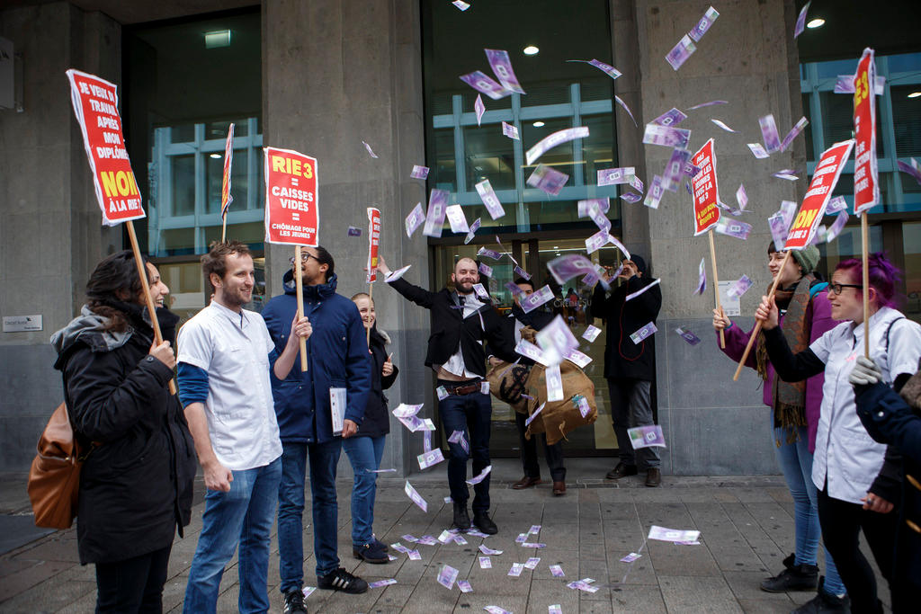 Demonstrators wave placards and throw money in the air