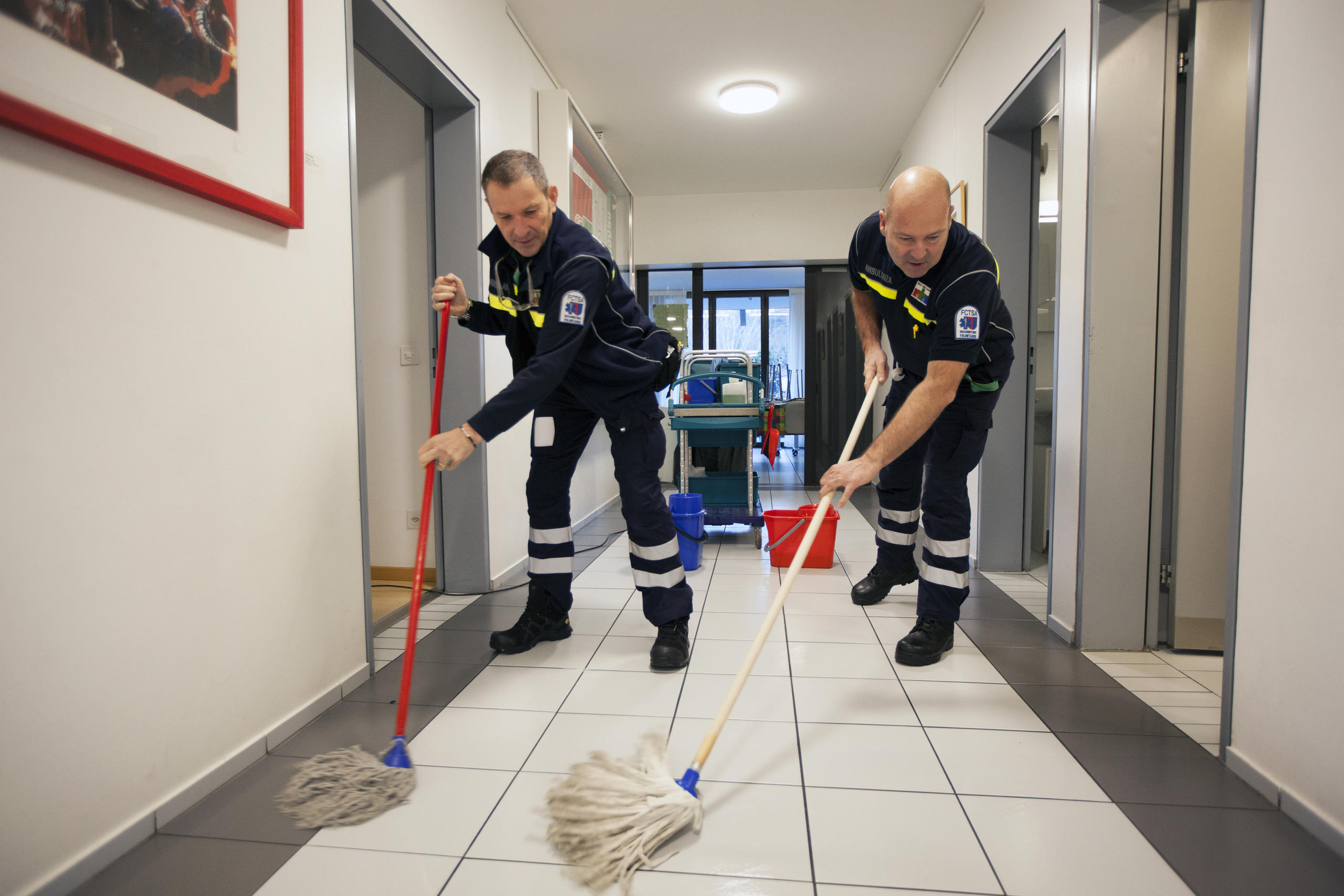 Paramédicos limpam o chão do ambulatório
