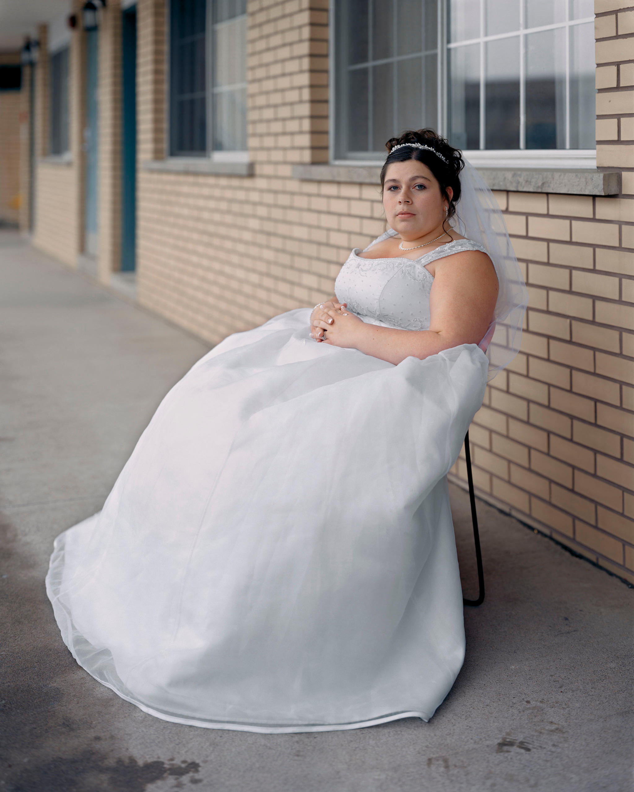 Frau in Hochzeitskleid auf einem Stuhl