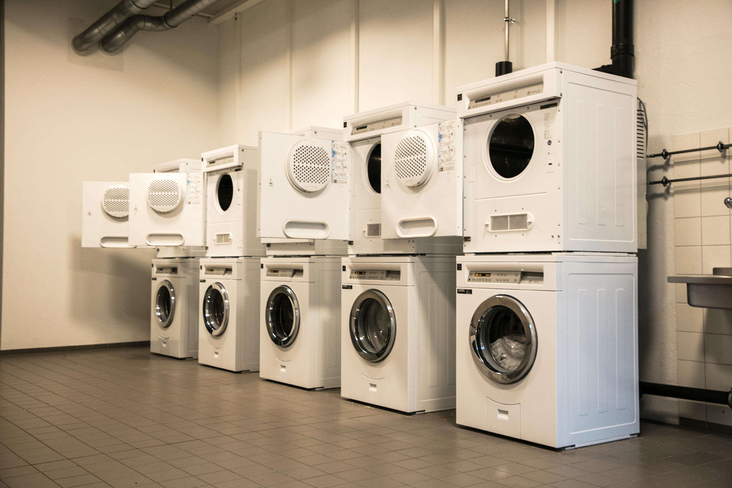 Cinco lavadoras y secadoras en una lavandería común