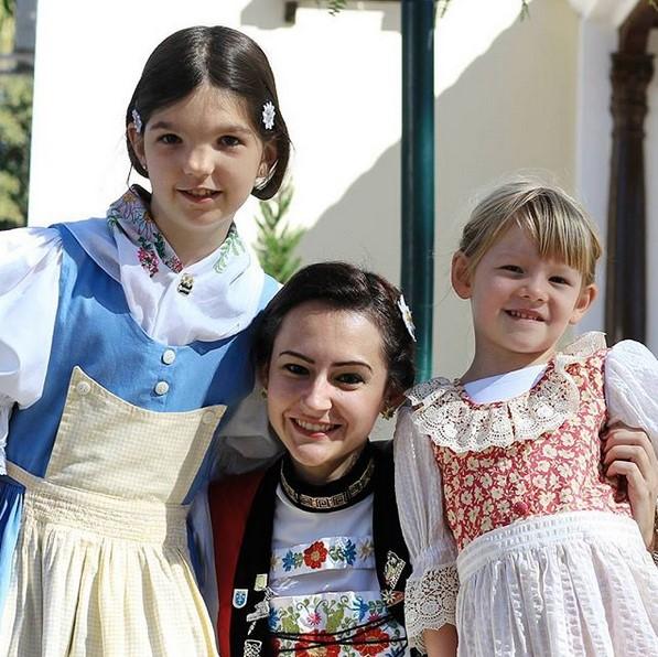 una donna e due bambine che indossano costumi tradizionali.