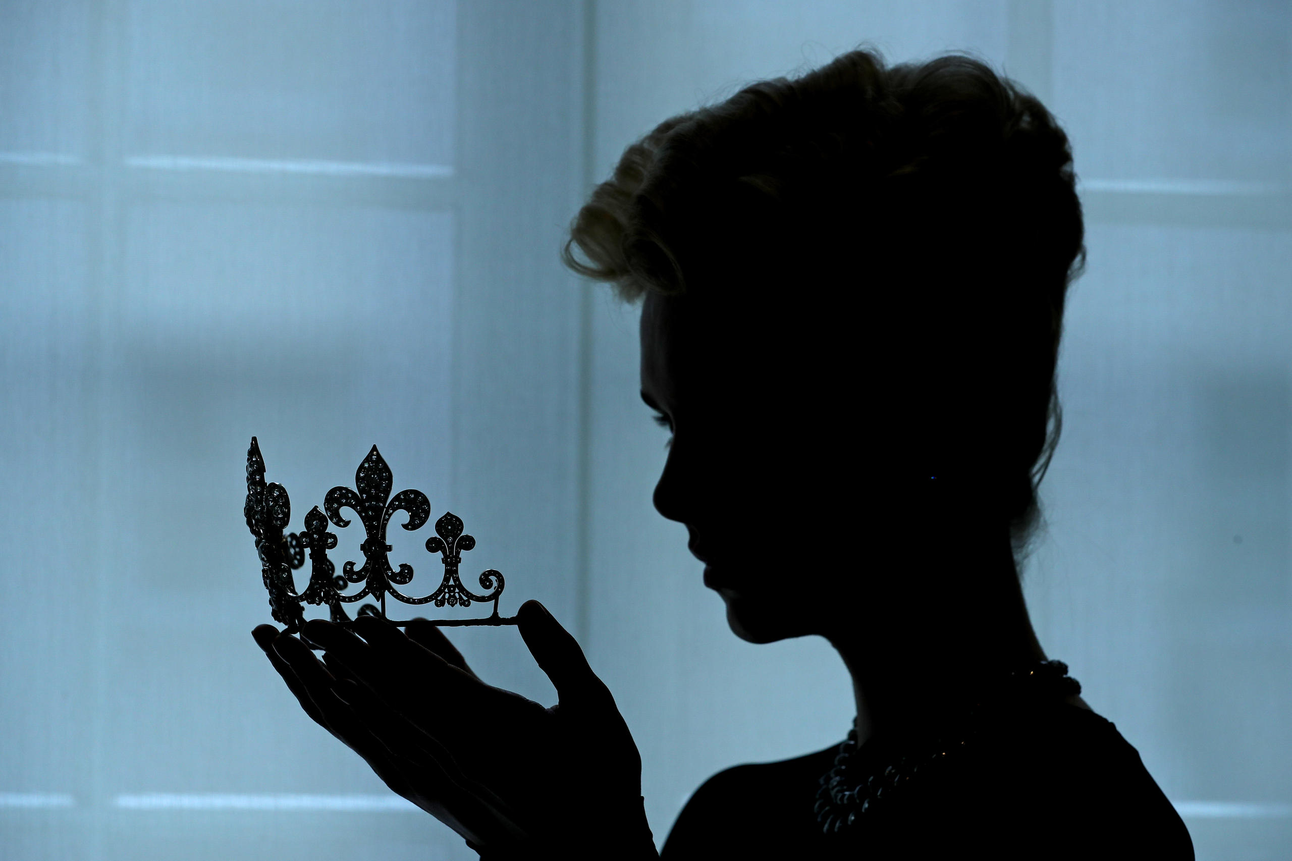 Silhouette einer Frau, die eine Lilienblüten-Tiara in der Hand hält