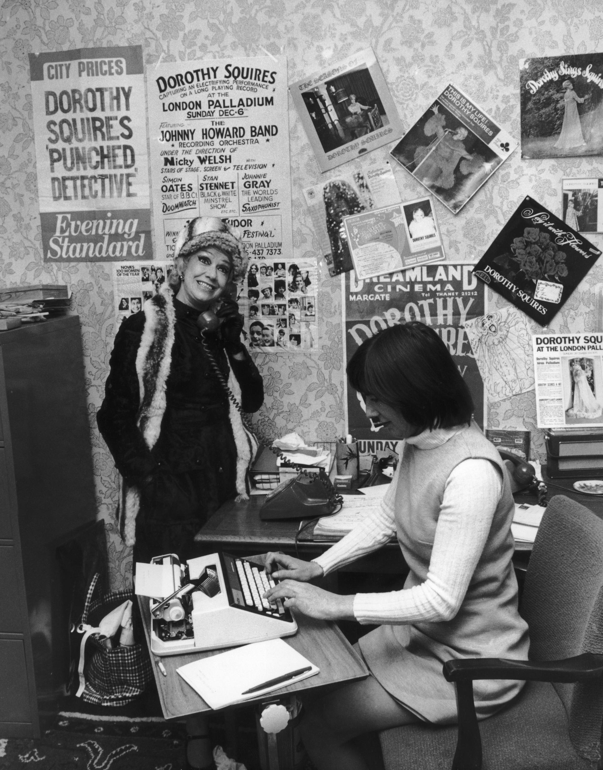 Zwei Büro Angestellte am Boden sitzend, eine Dame schreibt an die Wand