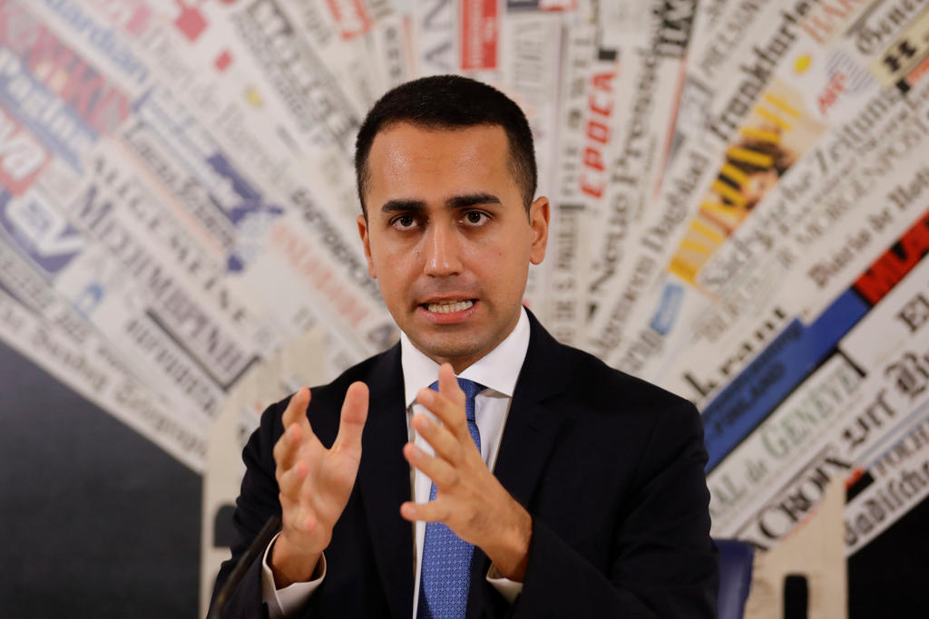 Primo piano di Luigi di Maio; sullo sfondo un collage-mosaico di testate giornalistiche di tutto il mondo