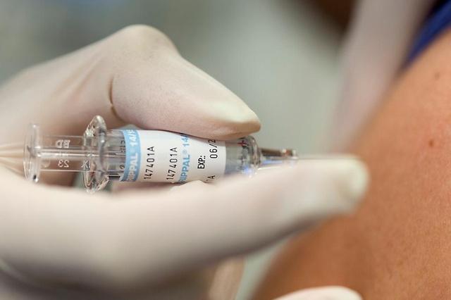 Foto de una mano aplicando una vacuna