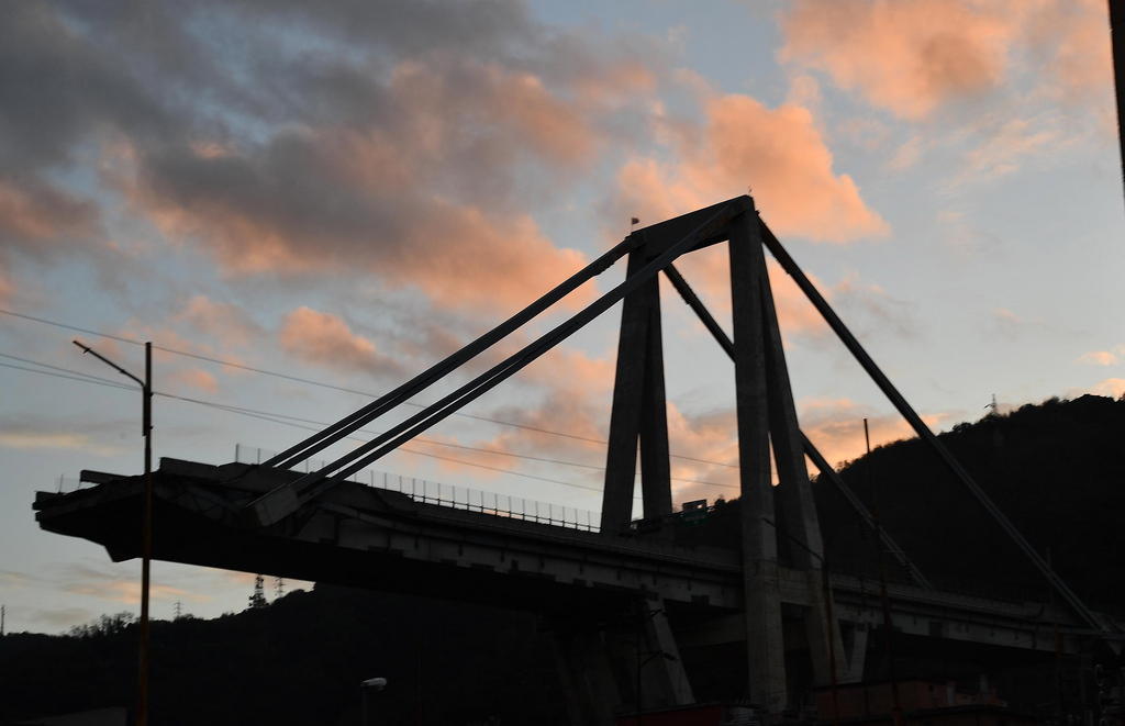 Quel che rimane del ponte in controluce con le nuvole rosse e il cielo azzurro