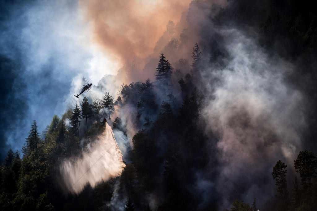 elicottero sopra a una foresta in fiamme