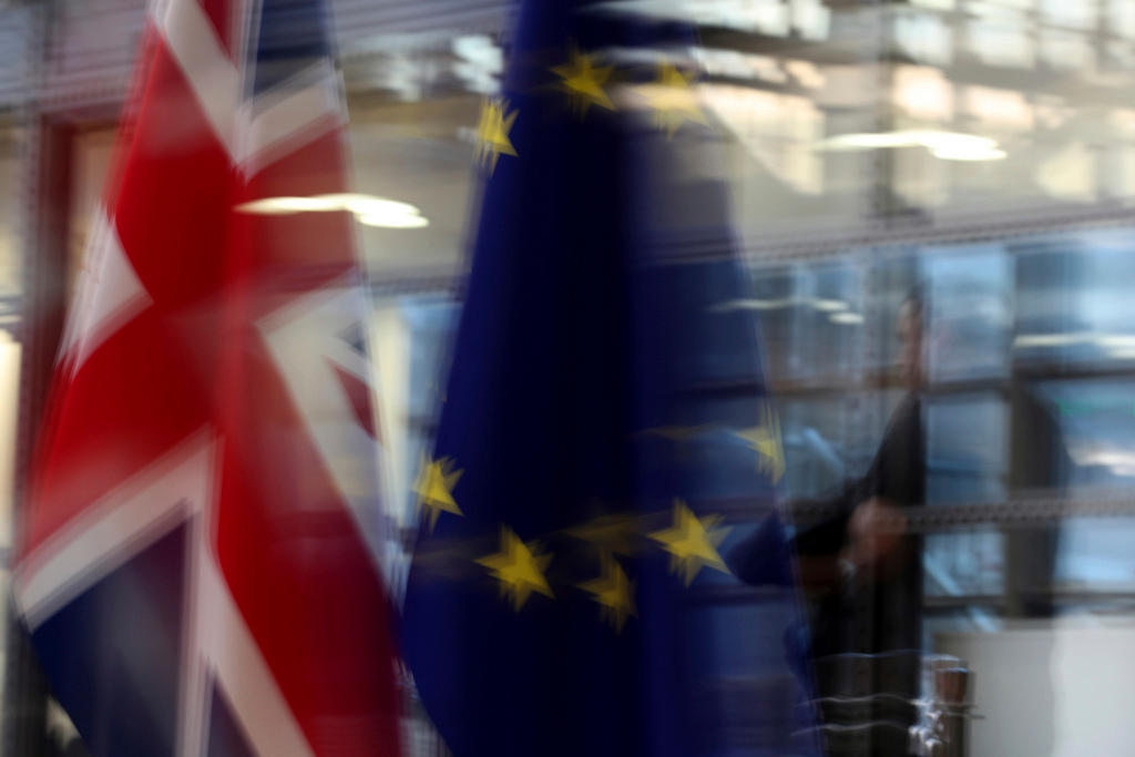 Immagine sfocata di due bandiere, una britannica, l altra dell Unione Europa, vicino alle vetrate di un edificio