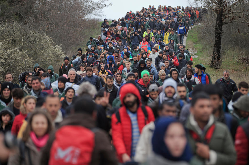 folla di migranti in cammino