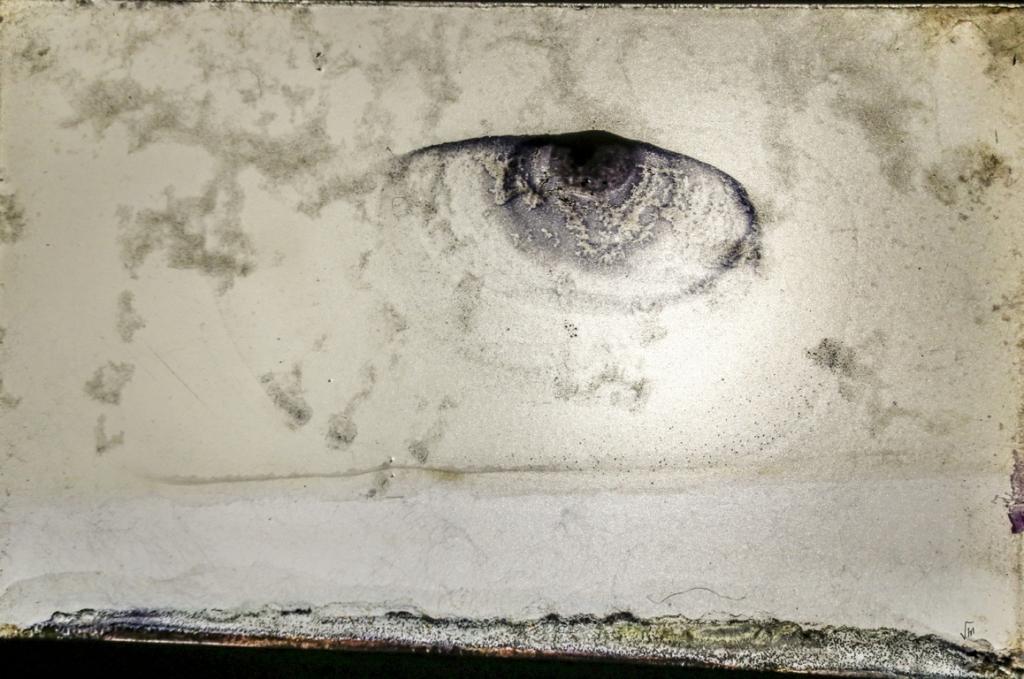 Forma de olho surgida numa superfície de fundo cinza