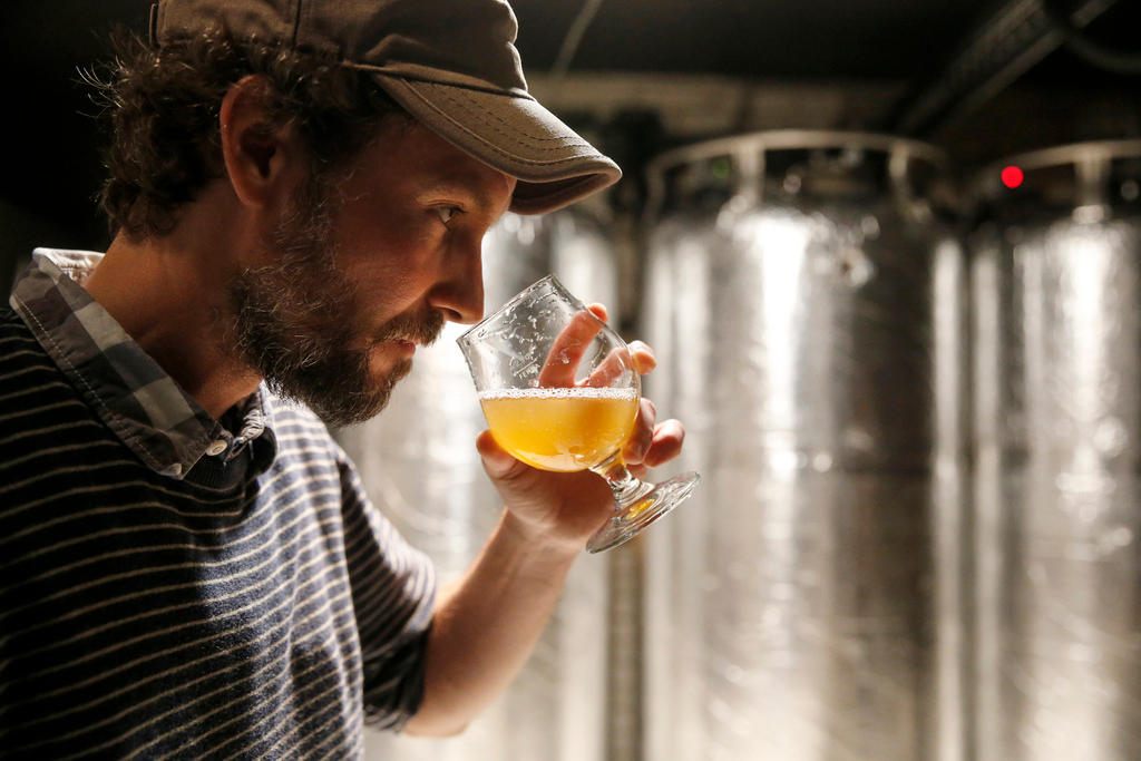 The brewer Christophe Haeni tastes a beer at the microbrewery Garage