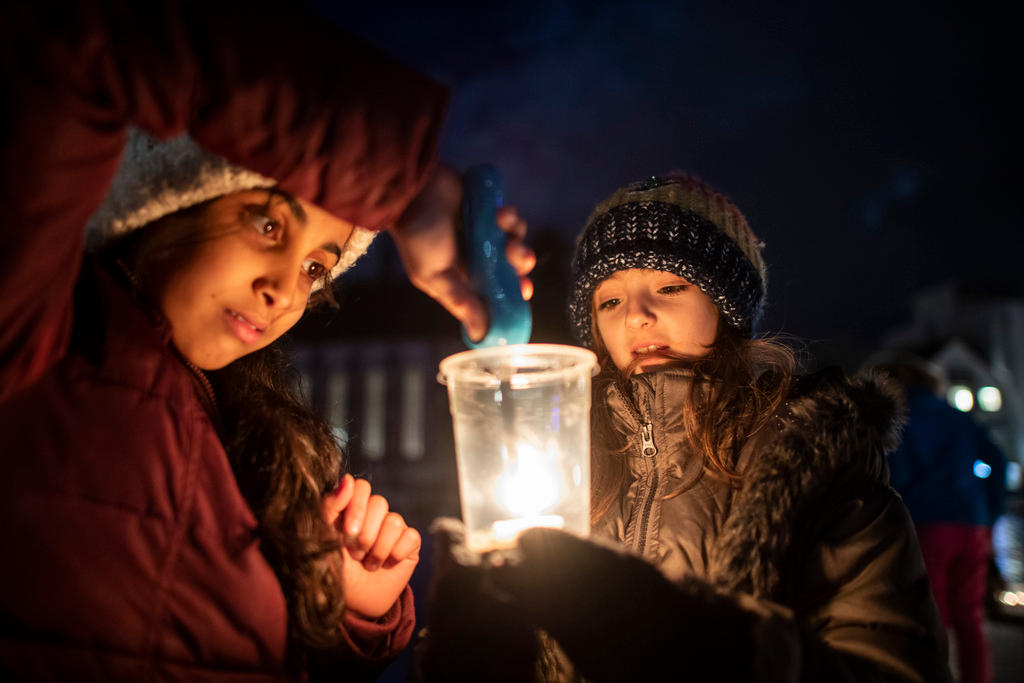 due bambini accendono una candela