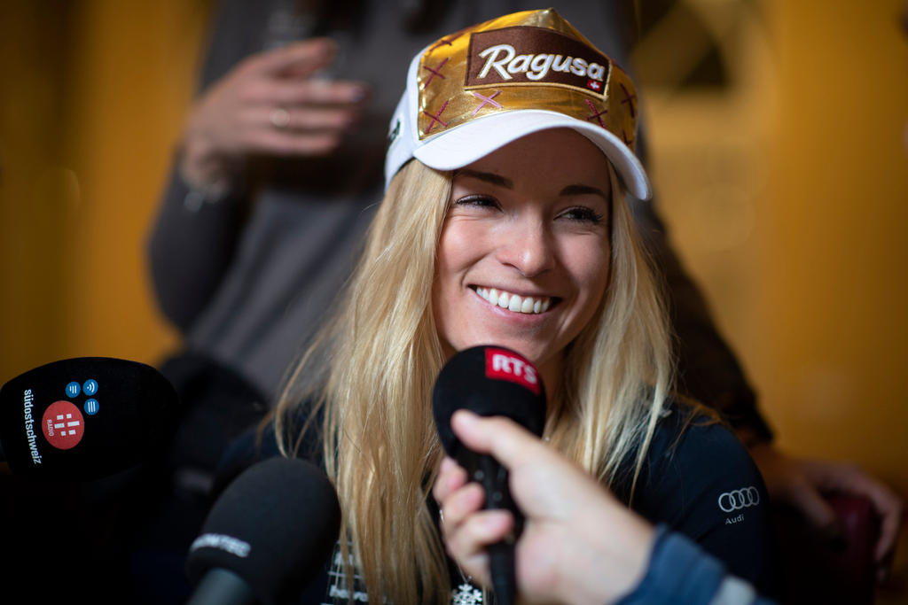 Lara Gut close up with hand holding a microphone in front of her