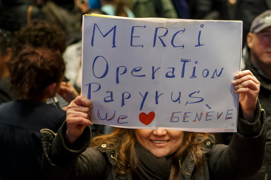 A woman holds sign praising the canton s Operation Papyrus