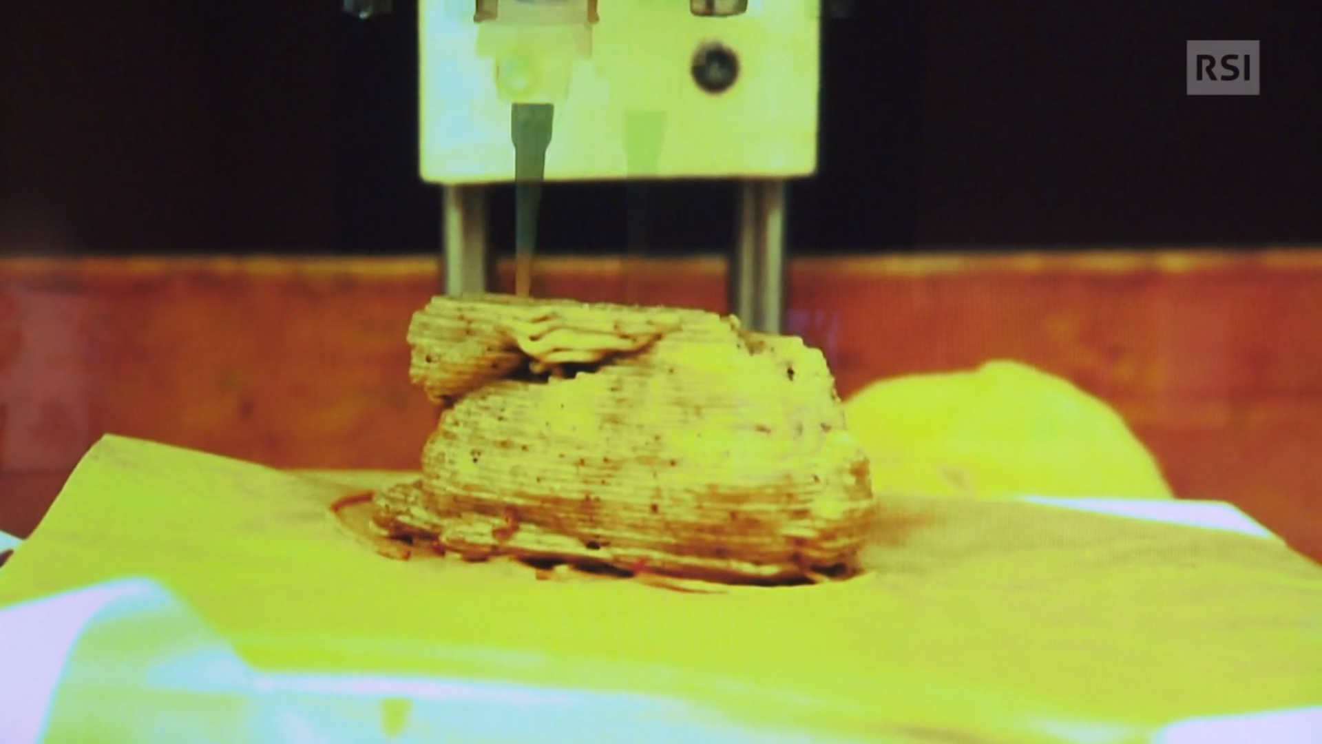 Ugello di una stampante 3D dà forma a una figura che assomiglia a un coniglietto di cioccolata.