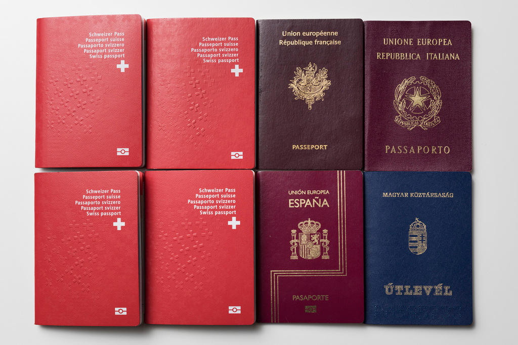 أربع جوازات سفر سويسرية وبجوارها أربع جوازات سفر أجنبية
