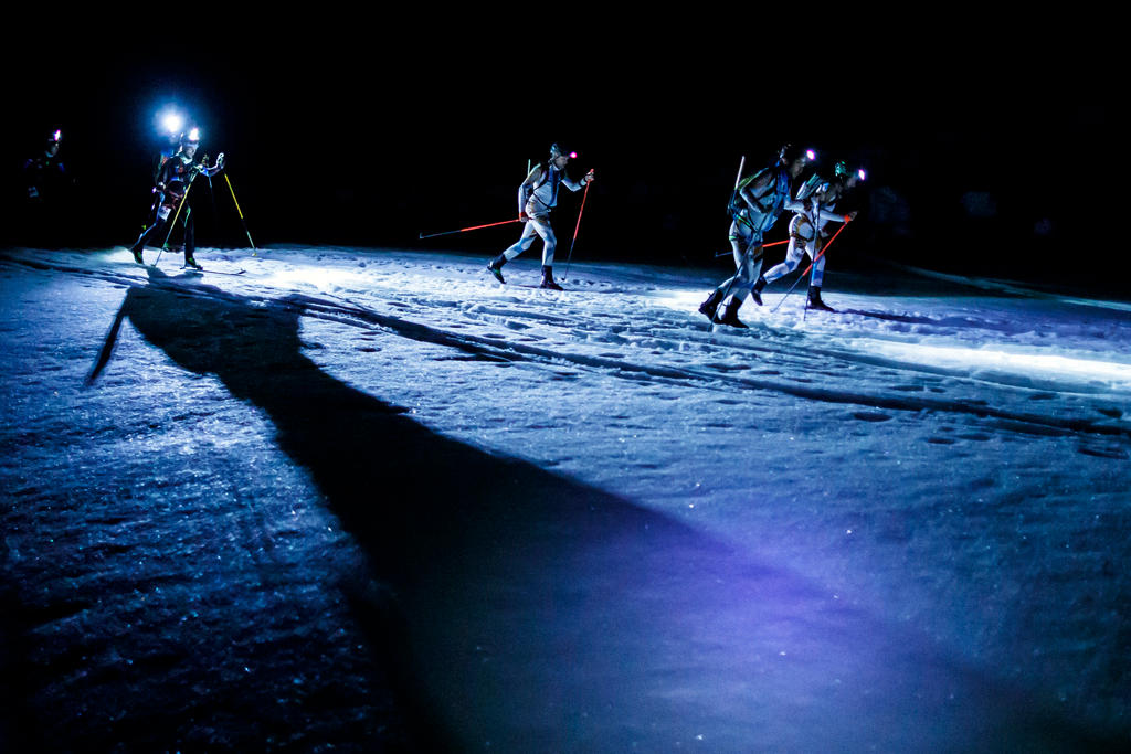 Hombres esquiando de noche en glaciares