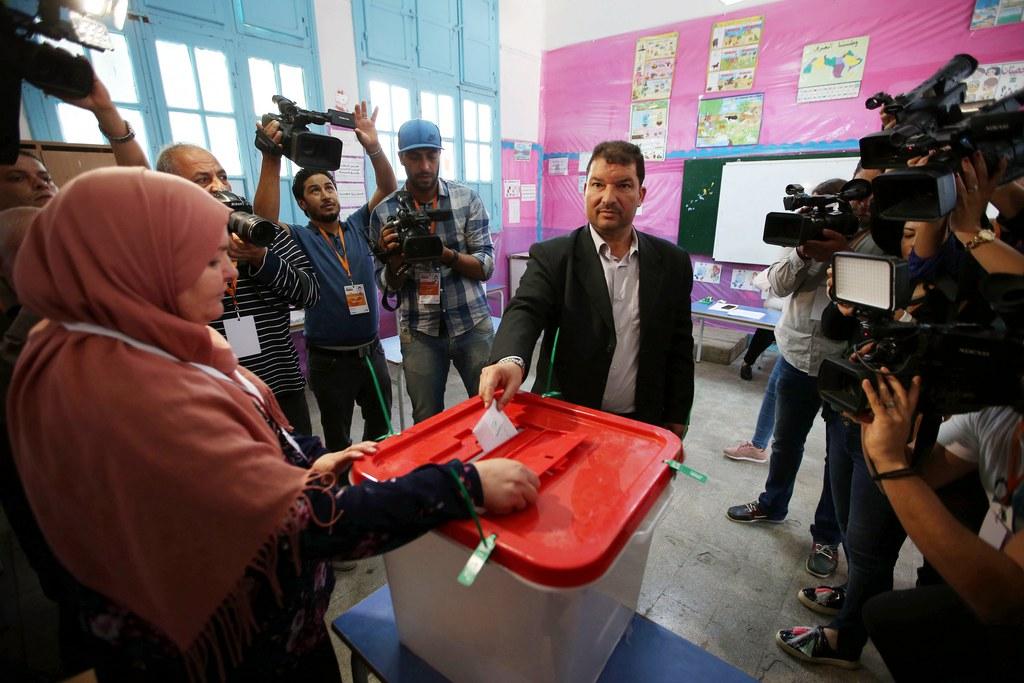 رجل يضع ورقة في صندوق اقتراع