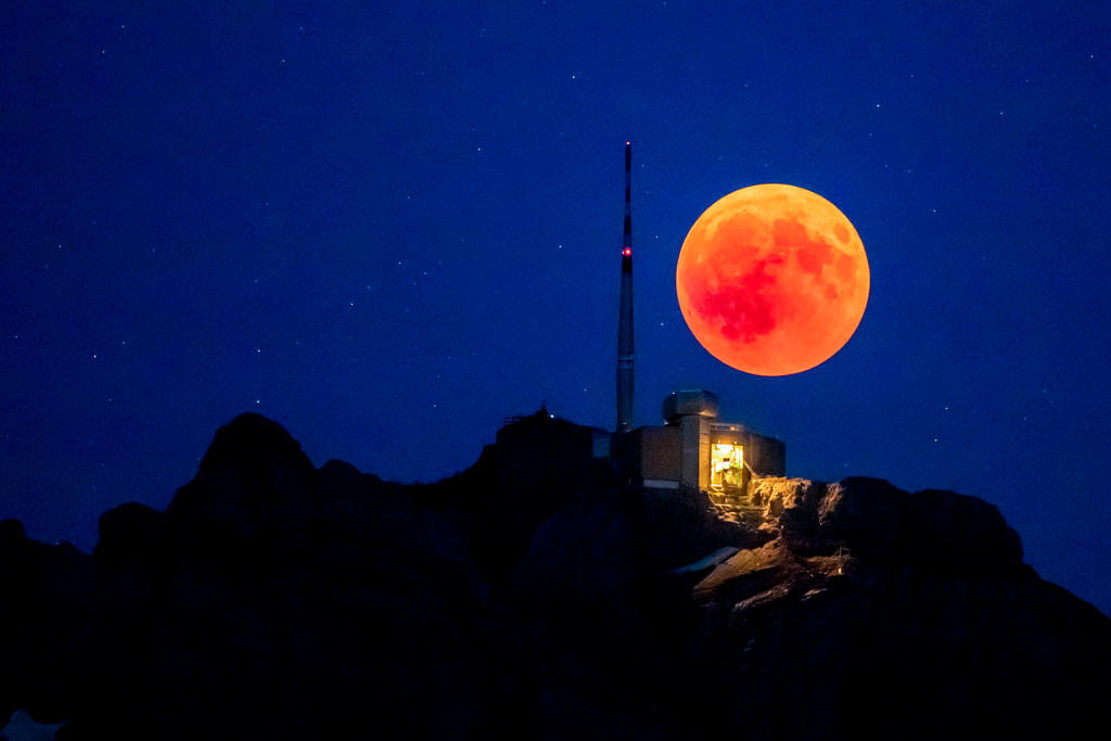 оранжево-красная луна на темно-синем небе