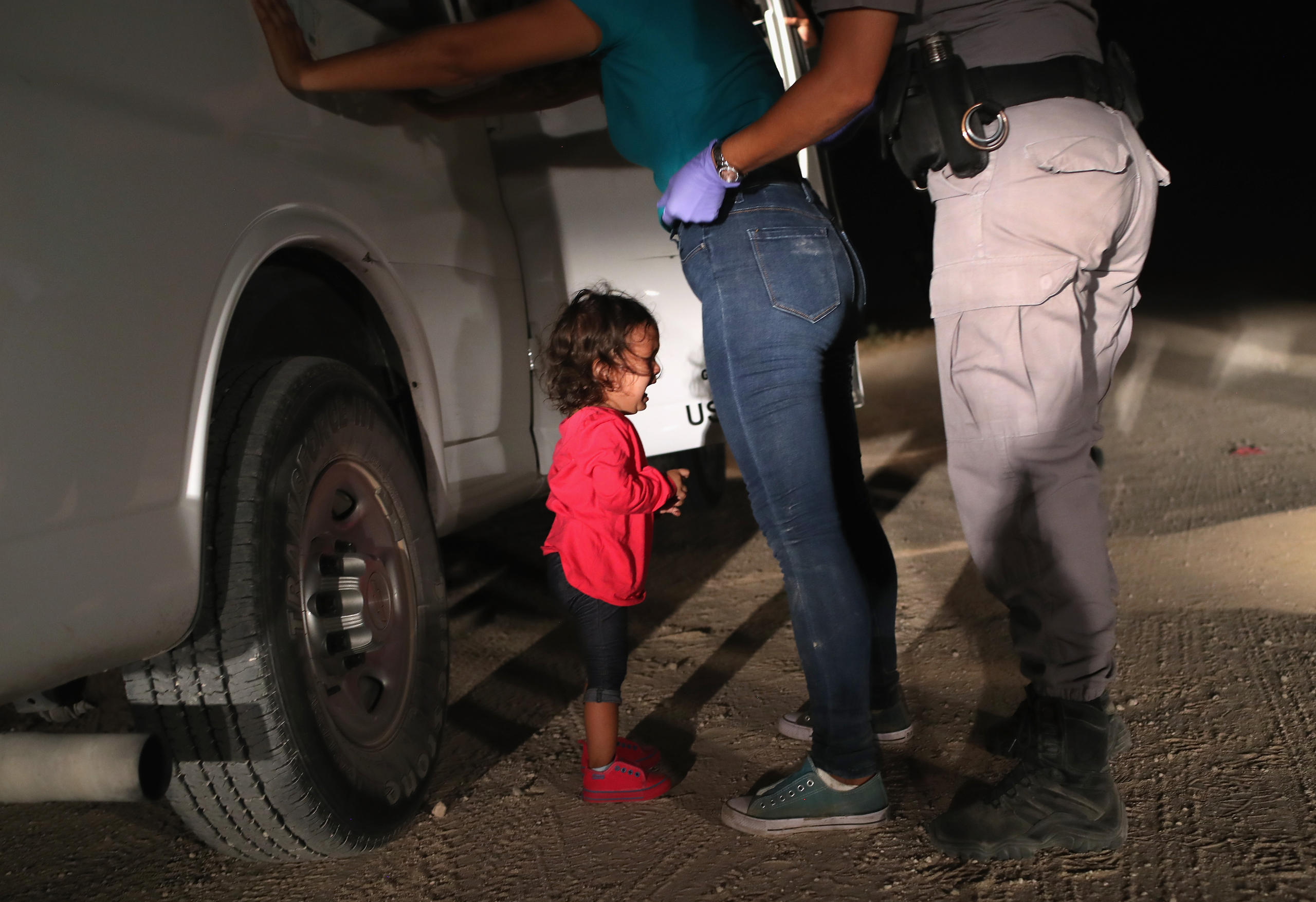 niña pequeña llorando mientras cachean a su madre