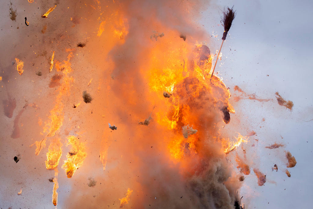 Immagine di un esplosione; tra i frammenti che si allontanano dalle fiamme si distingue una scopa