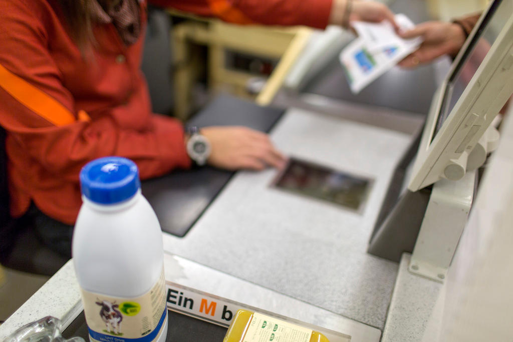 A Migros cashier hands over the receipt to the customer