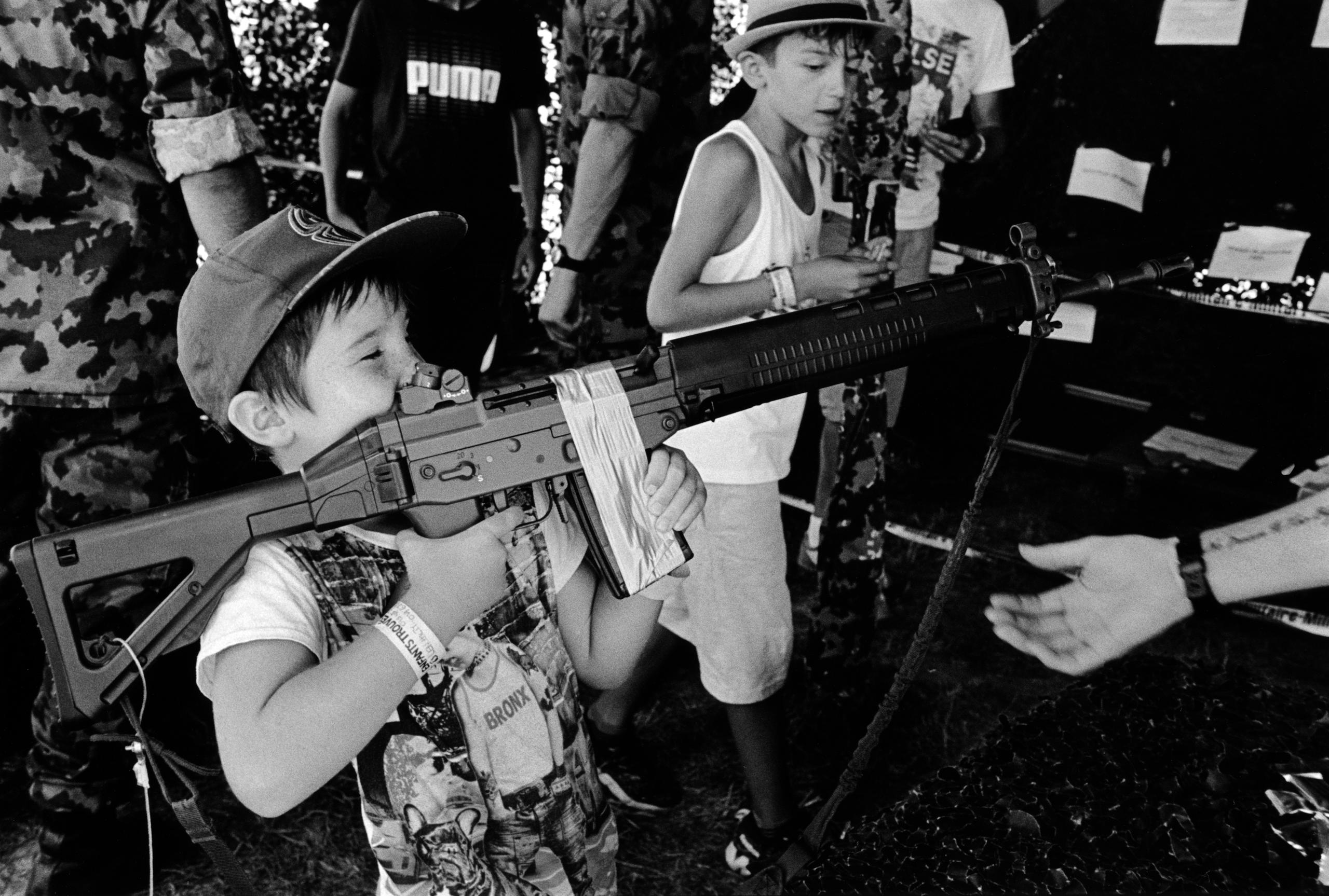 Un niño disparando con un rifle