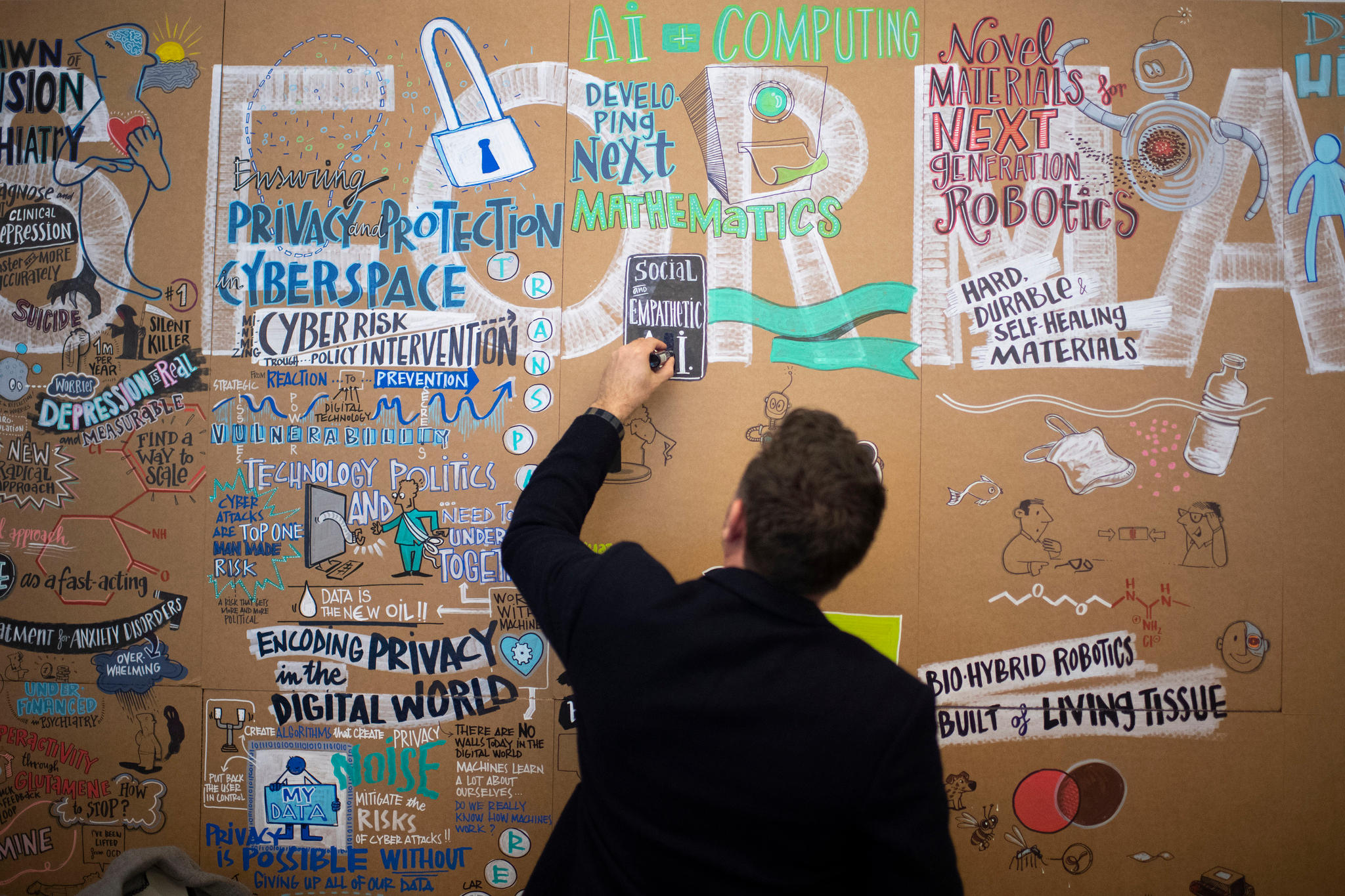 Un hombre escribe sobre un mural