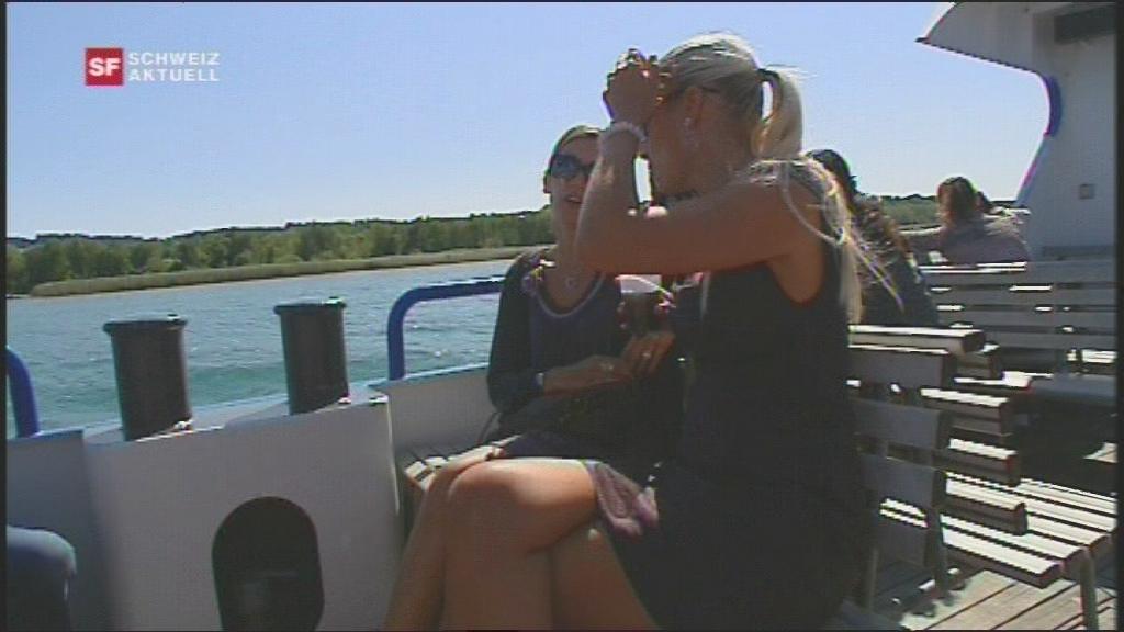 Two women in dresses are sitting on a boat